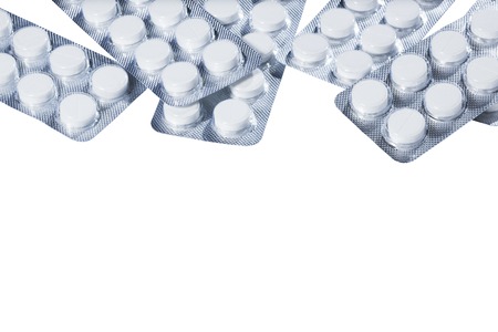 White pills in silver packaging on a white background.