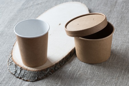 Disposable kraft paper cup on a wooden board.の写真素材