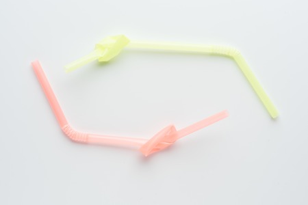 Disposable plastic knotted drinking straw. Conceptual photo about environmental issues.