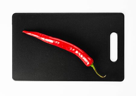 Red hot pepper on a black cutting boardの写真素材