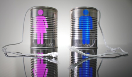 Tin can telephone with a broken string. Male and female icons on each can respectively.の写真素材