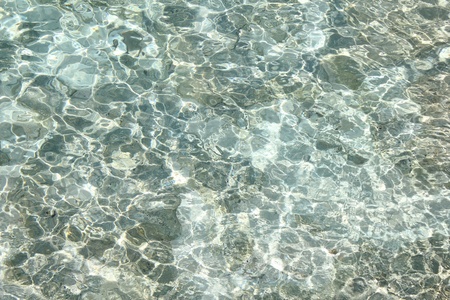 Clear ocean water over rocks with caustic effects.の写真素材