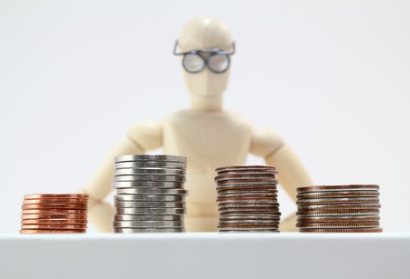 Character with glasses staring at stacks of US coins.の写真素材