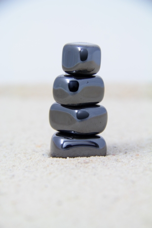 Stacked metallic stones on sand の写真素材