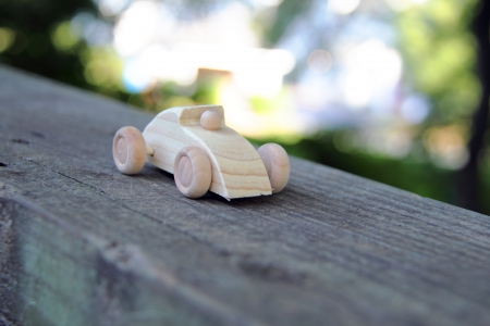 Wooden race car on a wood fence の写真素材