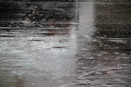 Black asphalt during a rain storm.