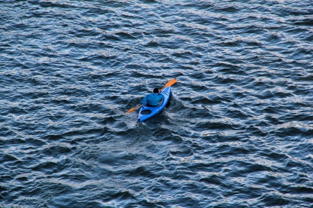 Man in a blue canoe on a lake.の写真素材