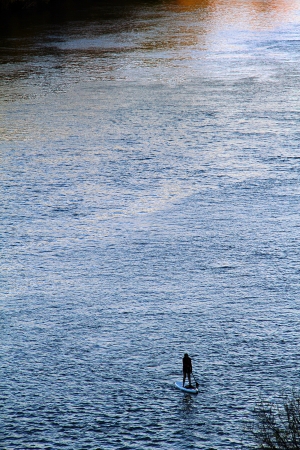 Paddle boarder crossing a riverの写真素材