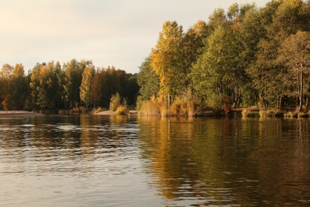 Autumn trees reflecting off the waterの写真素材