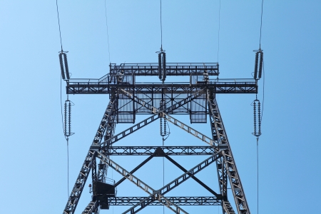 Power lines and electricity pylon  against blue skyの写真素材