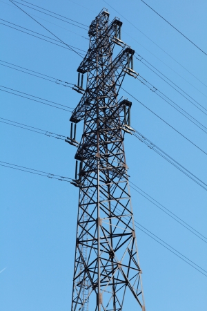 Power lines and electricity pylon  against blue skyの写真素材