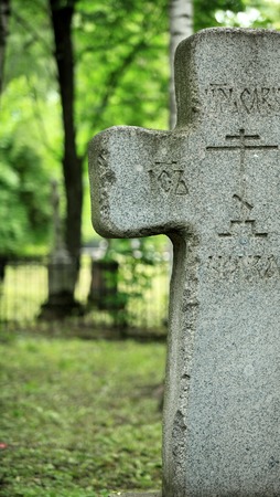 granite grave cross on a background of lush green の写真素材