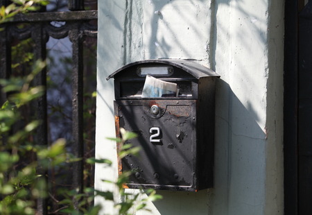 Old mailbox with newspaper on the wallの写真素材
