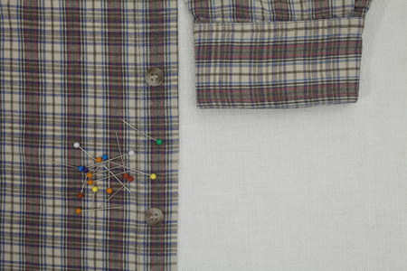 checkered shirt and pins on a tailor's table, copy space