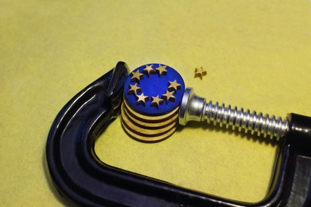 euro coin in the clamp  pressure after brexit, conceptual image crisis of the European Unionの写真素材