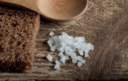 rough rye bread with coarse salt on a wooden table, macro shotの写真素材