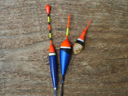 three fishing bobbers on wooden background close to still lifeの写真素材