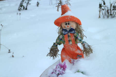 scarecrow on a field covered with deep snow winter landscapeの写真素材