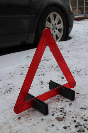 red warning triangle on winter snowy road, danger concept