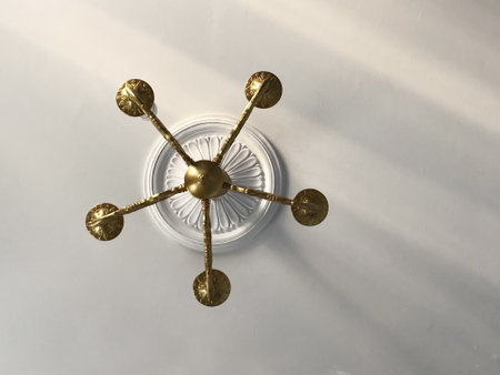 golden chandelier in classic style on the ceiling with stucco rosette, interiorの写真素材