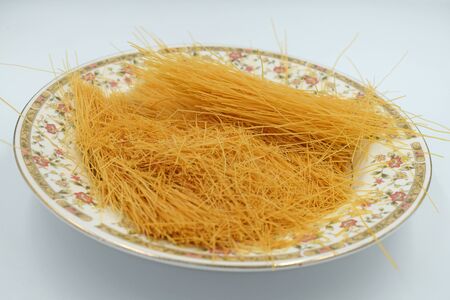uncooked rice vermicelli pasta on a white backgroundの写真素材