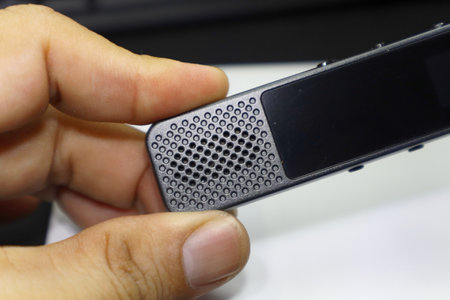 Witness the potential of a voice recorder as it rests confidently in a man's hand, ready to document and preserve memories, conversations, and creativity.の写真素材