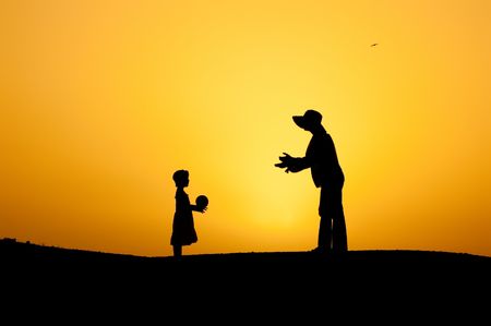 Mother and daughter are playing with the ball at sunset.の写真素材