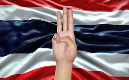 3d Illustration of a hand showing 3 fingers, a political symbol, on Thai flag background, as an act...