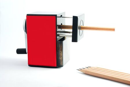 Rotary Pencil Sharpener. Red black rotary pencil sharpener with brown pencil on white background.の写真素材