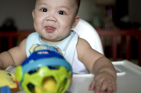 A baby boy is sticking his tongue outの写真素材