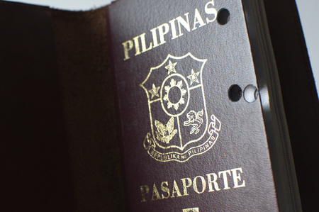 A still life of a old hole-ridden philippine passport against white backgroundの写真素材