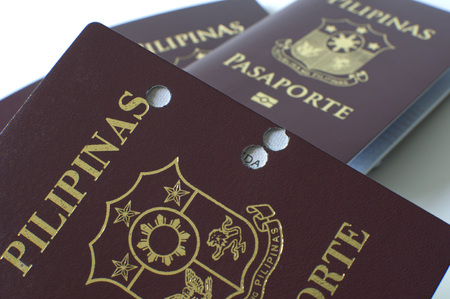 A still life of a old hole-ridden philippine passport against white backgroundの写真素材