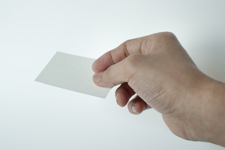 A man is holding a white blank calling card against white backgroundの写真素材