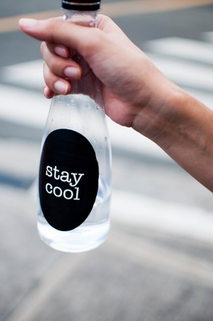 A woman is holding a platic bottle with water outdoorの写真素材