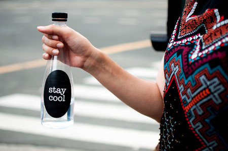 A woman is holding a platic bottle with water outdoorの写真素材