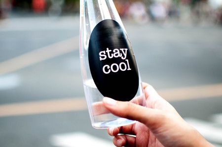 A woman is holding a platic bottle with water outdoorの写真素材