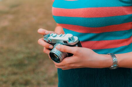 A young woman is carrying a vintage camera outdoor