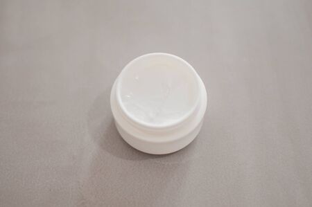 A beauty cream on a plastic container on a gray backgroundの写真素材