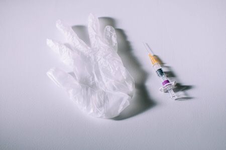 Medical syringe and gloves on a white backgroundの写真素材