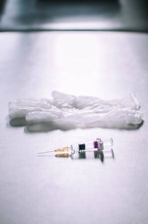Medical syringe and gloves on a white background