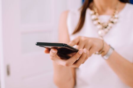 A young woman is using a smartphone indoorの写真素材