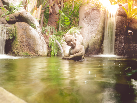 Girl doll on small pond.の写真素材