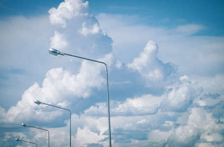 Electronic pole was arranged with a large group of white clouds floating in the sky.の写真素材