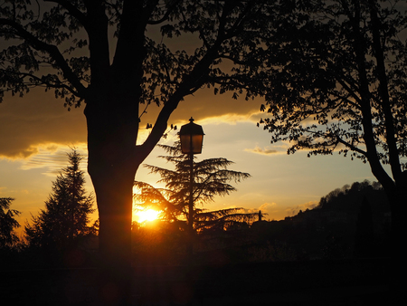 Fiery sunset from the old city of Bergamo to the hills surrounding the townの写真素材