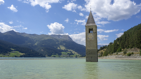 Curon, Italy. View of the old bell tower of the village rising from the waters of Resiaの写真素材