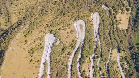 Drone aerial view of the mountain road in Italy. Bends creating beautiful shapes