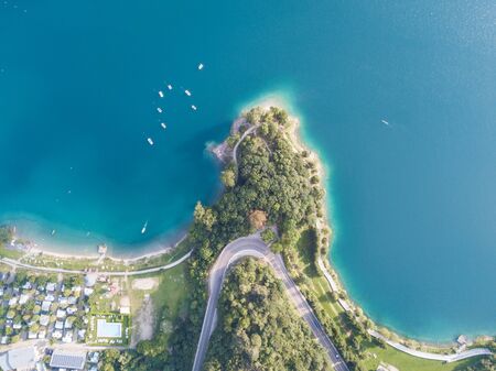 Up and down drone aerial view of the lake Ledro. A natural alpine lake. Amazing turquoise, green and blue natural colors. Italian Alps. Italy. Touristic destination. Summer timeの写真素材