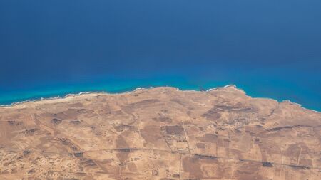 Earth's line. A perspective of the ground's colors and shapes. Aerial view of the Egyptian coast overlooking the Mediterranean sea. View from the airplane window. Sea with fantastic turquoise colorsの写真素材