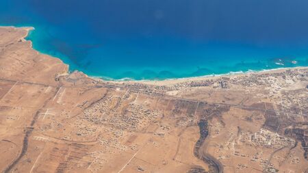 Earth's line. A perspective of the ground's colors and shapes. Aerial view of the Egyptian coast overlooking the Mediterranean sea. View from the airplane window. Sea with fantastic turquoise colorsの写真素材