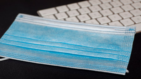 Surgical or medical mask and keyboard for pc. Office context.の写真素材